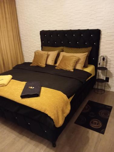 a bedroom with two beds with yellow pillows at Black Diamond Lux - deluxe riverside apartment in Senta