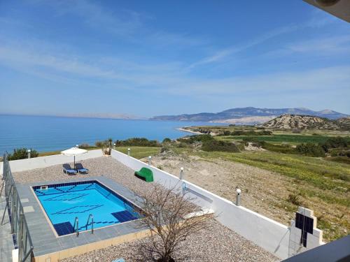 a swimming pool with a view of the water at Pearl Villas Apolakkia - Beach Front Villas with Private Pool in Apolakkiá