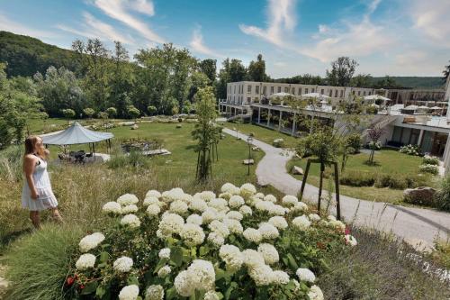 a woman looking at a garden with white flowers at Schlosspark Mauerbach - Adults only in Mauerbach