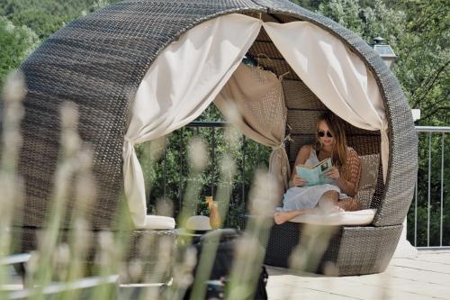 a woman sitting in a wicker gazebo at Schlosspark Mauerbach - Adults only in Mauerbach