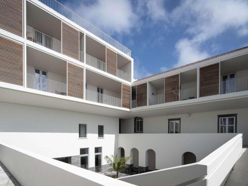 an external view of a white building with balconies at Mercure Ponta Delgada Azores in Ponta Delgada