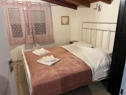 Un dormitorio con una cama con dos toallas encima. en Sweet Home Wooden, en Kastoria