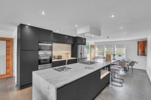 a kitchen with black cabinets and a marble counter top at The Duke - North East Escapes in Bamburgh