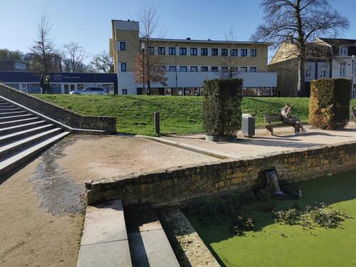 a person sitting on a bench next to a body of water at Hotel Parkzicht in Valkenburg