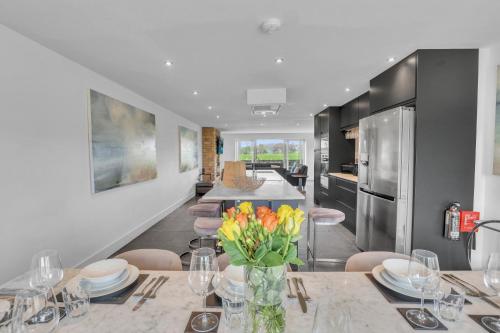 a kitchen with a dining table with yellow flowers on it at The Duke - North East Escapes in Bamburgh
