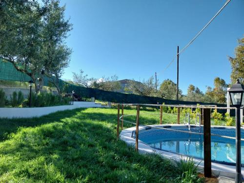a backyard with a swimming pool and a fence at Casa Lachesi in Caccamo
