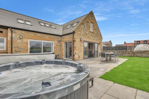 a hot tub in the backyard of a house at The Duke - North East Escapes in Bamburgh
