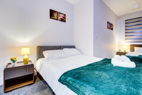 a bedroom with two beds with towels on them at 2 BR Flat 6 Mins From Heathrow Airport Flat 41 in Harmondsworth