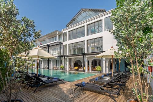 an exterior view of a building with a swimming pool at Anona Beachfront Phuket Resort-SHA EXTRA PLUS in Patong Beach