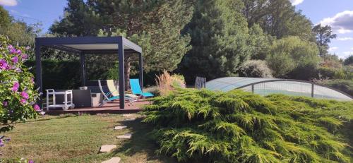 - un jardin avec un kiosque et 2 chaises dans l'établissement Rêve d'eau et de Nature, à Burgnac