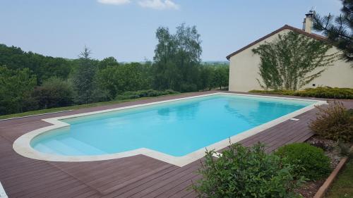 - une piscine sur une terrasse en bois à côté d'une maison dans l'établissement Rêve d'eau et de Nature, à Burgnac