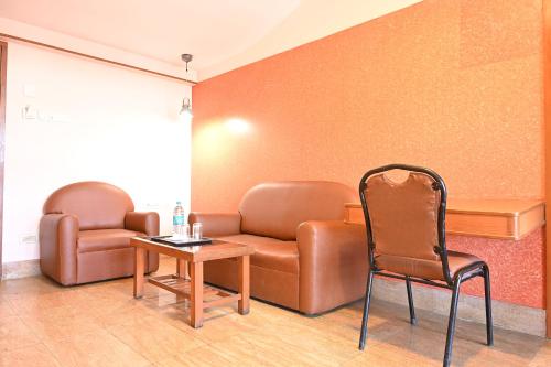 a waiting room with a couch and a chair at Bella Vagues By K Hotels in Chennai