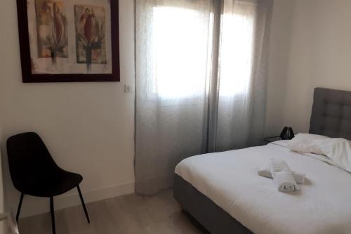 une chambre avec un lit, une chaise et une fenêtre dans l'établissement Appartement Aix, résidence calme avec piscine, à Aix-en-Provence