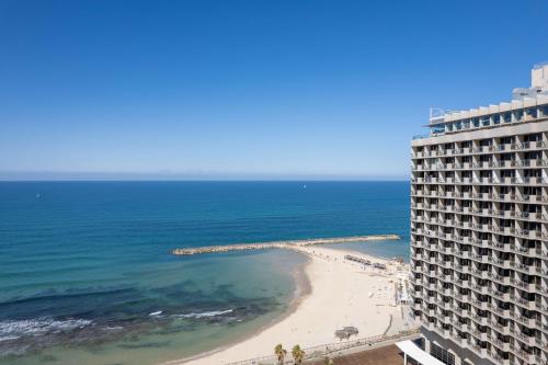 a view of the beach from the balcony of a building at The Vista At Hilton Tel Aviv in Tel Aviv