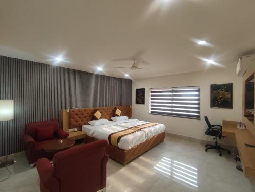 a bedroom with a bed and a desk and a chair at The Rajgir Residency in Rājgīr
