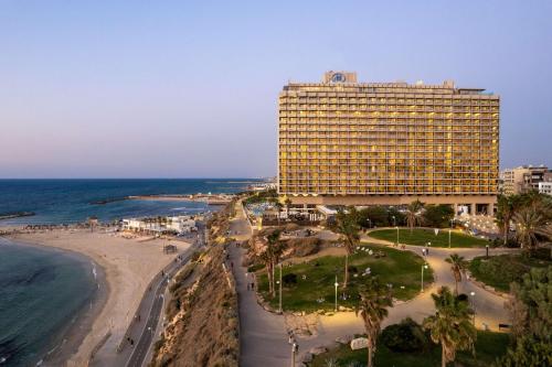 a large hotel on the beach next to the ocean at The Vista At Hilton Tel Aviv in Tel Aviv