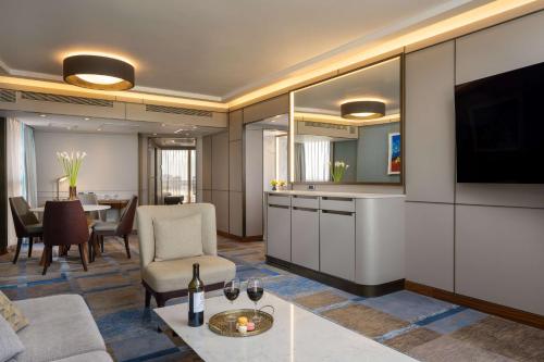 a living room with a couch and a tv and a table at The Vista At Hilton Tel Aviv in Tel Aviv