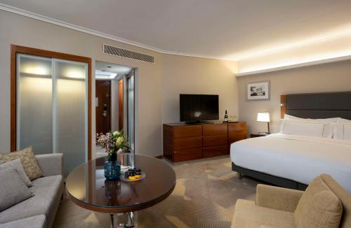 a hotel room with a bed and a coffee table at The Vista At Hilton Tel Aviv in Tel Aviv
