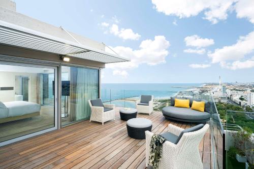a master bedroom with a balcony with a view of the ocean at The Vista At Hilton Tel Aviv in Tel Aviv