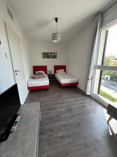 une chambre avec deux lits et une fenêtre dans l'établissement Appartement cosy à Valras-Plage 5 min à pied de la mer Climatisé 2 chambres Terrasse, à Sérignan