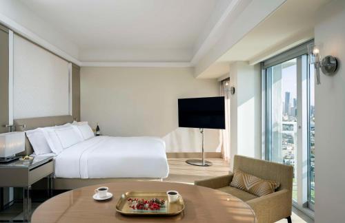a hotel room with a bed and a desk and a tv at The Vista At Hilton Tel Aviv in Tel Aviv