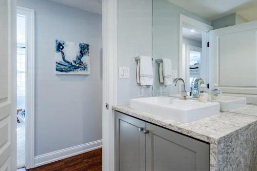 a white bathroom with a sink and a mirror at Renovated 3-Bedroom, 2-Bath Home in Ocean Pines Peaceful Retreat Near Ocean City in Berlin