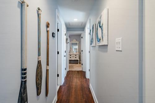 a hallway with white walls and wooden floors and a hallway with baseball bats at Renovated 3-Bedroom, 2-Bath Home in Ocean Pines Peaceful Retreat Near Ocean City in Berlin