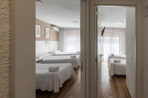 a hospital room with two beds and a doorway at Hostal Gran Vía in Pinto
