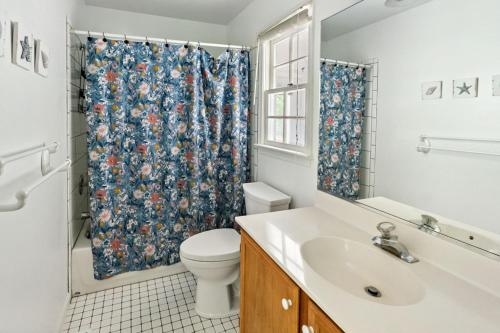 ein Badezimmer mit Toilette und Duschvorhang in der Unterkunft Pet-Friendly Ocean Pines Cottage Family-Friendly Retreat with Amenities in Berlin