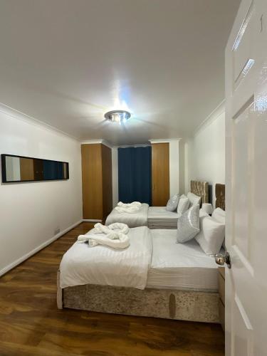 a bedroom with two beds and a tv on the wall at 3 Bedrooms Apartment with security 24 hours in London