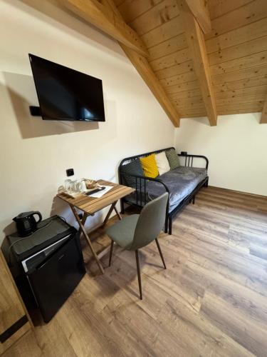 a small room with a bed and a table with a small table sidx sidx at Penzion Farma Žleby in České Žleby