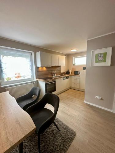 a kitchen with two chairs and a table in a room at Ferienwohnung Hollmann in Kaufbeuren