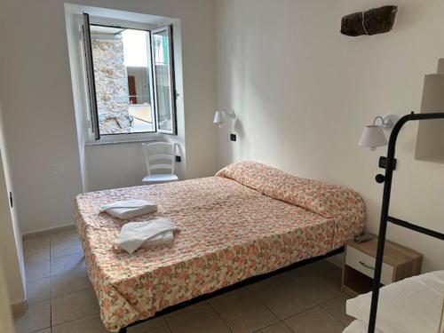 a small bedroom with a bed and a window at Riomaggiore Appartamenti in Riomaggiore