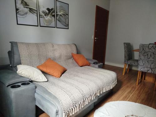 Una sala de estar con un sofá con cojines naranjas. en Paraíso no Jockey de Itaparica, en Vila Velha