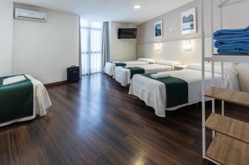 a row of beds in a room with wooden floors at Hostal Gran Vía in Pinto