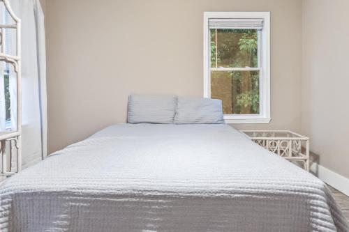 a white bed in a white room with a window at Charming Single-Family Home Between Ocean City & Assateague Island Pet-Friendly Retreat in Berlin