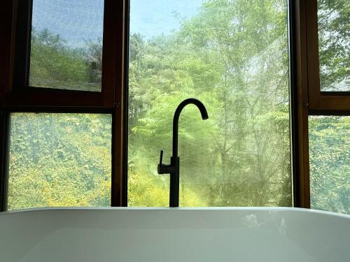 a bath tub in front of a window with a sink at Once Linya Xiaoyuan in Chongqing