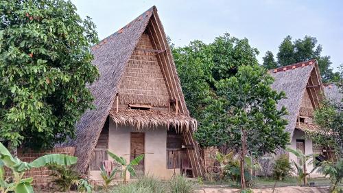 an old house with a thatched roof at Eco Lotus Kampot in Kampot