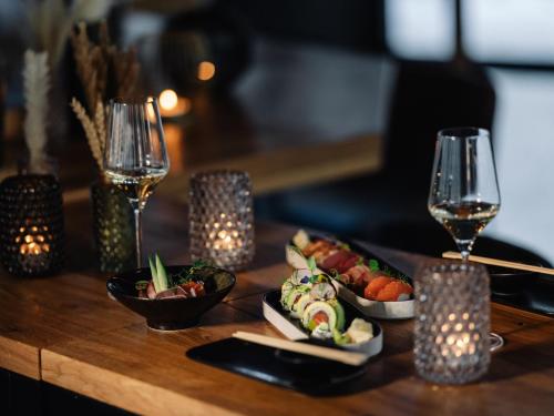 a table with plates of food and glasses of wine at JOHANN Schladming in Schladming