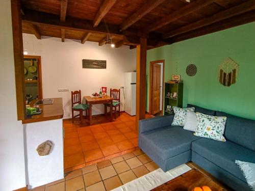 a living room with a blue couch and a table at Casita Aetheria in Cereceda