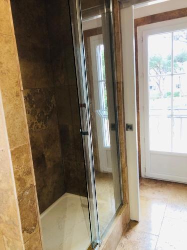 - une douche en verre dans une pièce à côté d'une porte dans l'établissement Charmant studio, à Saint-Tropez