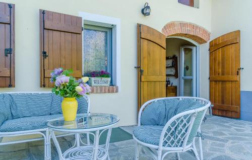 a table and chairs with a vase of flowers on it at Gorgeous Home In Ferrere With Kitchen in Ferrere