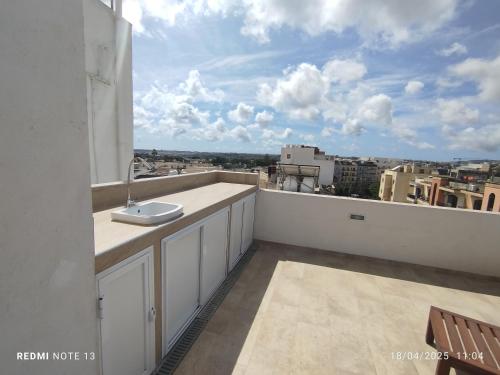 a balcony with a sink and a view of a city at Joanna's Penthouse in Lija