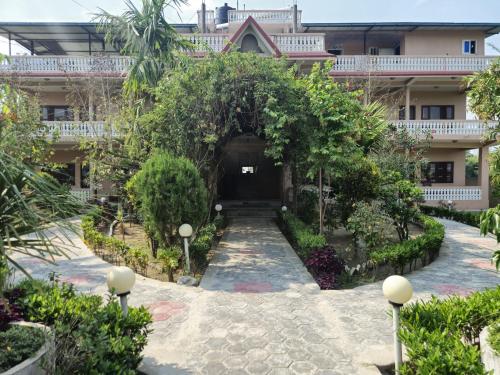 索拉哈Hotel Tree Tops的一座带树木庭院的建筑的入口