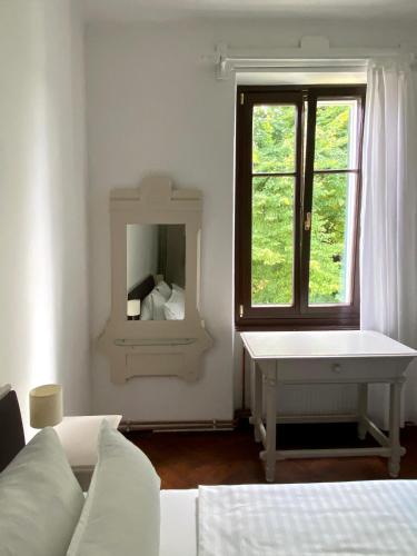 a white room with a bed and a mirror at Villa Streintz in Millstatt