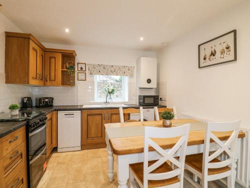 a kitchen with a table and chairs in a kitchen at The Old Parlour in Alton