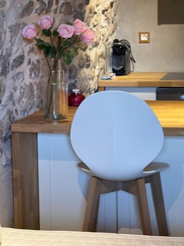 a vase of pink roses sitting on a counter at Mani Stone Studios in Oítilon