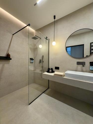 a bathroom with a shower and a sink and a mirror at SunSet Let`s Sea Baltic Spa in Gąski