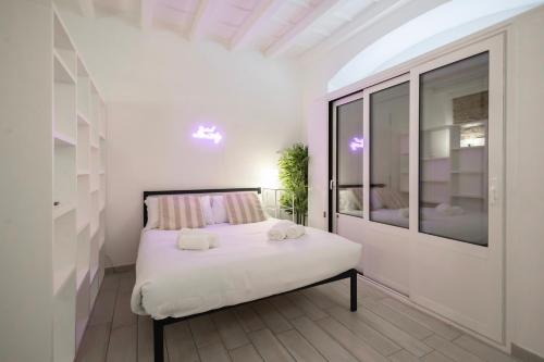 a white bedroom with a bed and a window at Flora 57 - Splendido Loft nel Cuore dei Navigli in Milan