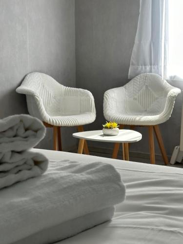 a bedroom with two chairs and a table and a bed at Aglaé Touquin, 25 min Disney in Touquin